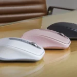 Ba phiên bản chuột Logitech MX Anywhere 3S màu đen, trắng và hồng trên mặt bàn kính, thể hiện khả năng hoạt động trên nhiều bề mặt.