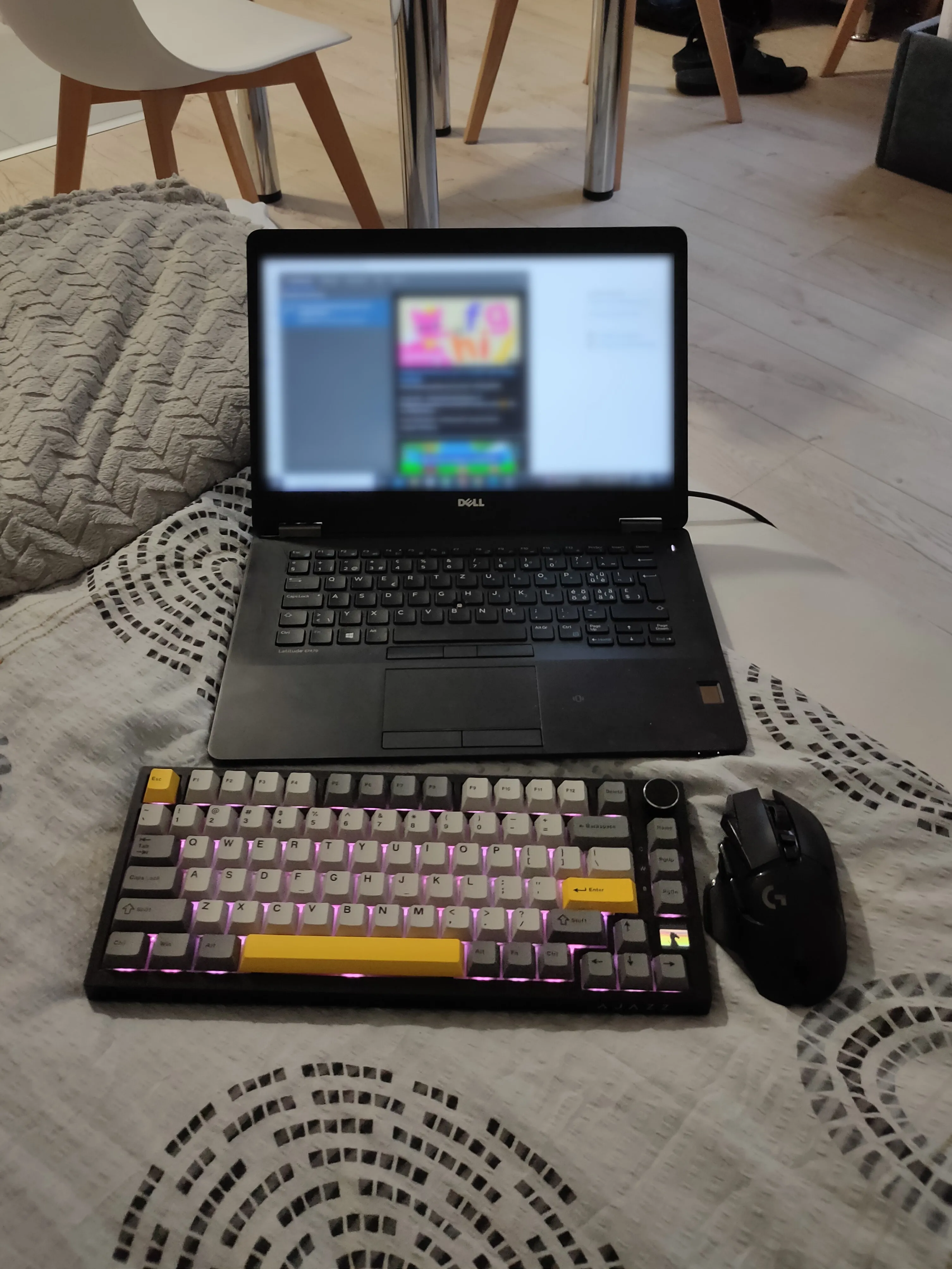 Bàn phím không dây và chuột đặt trên giường bên cạnh một chiếc laptop mở