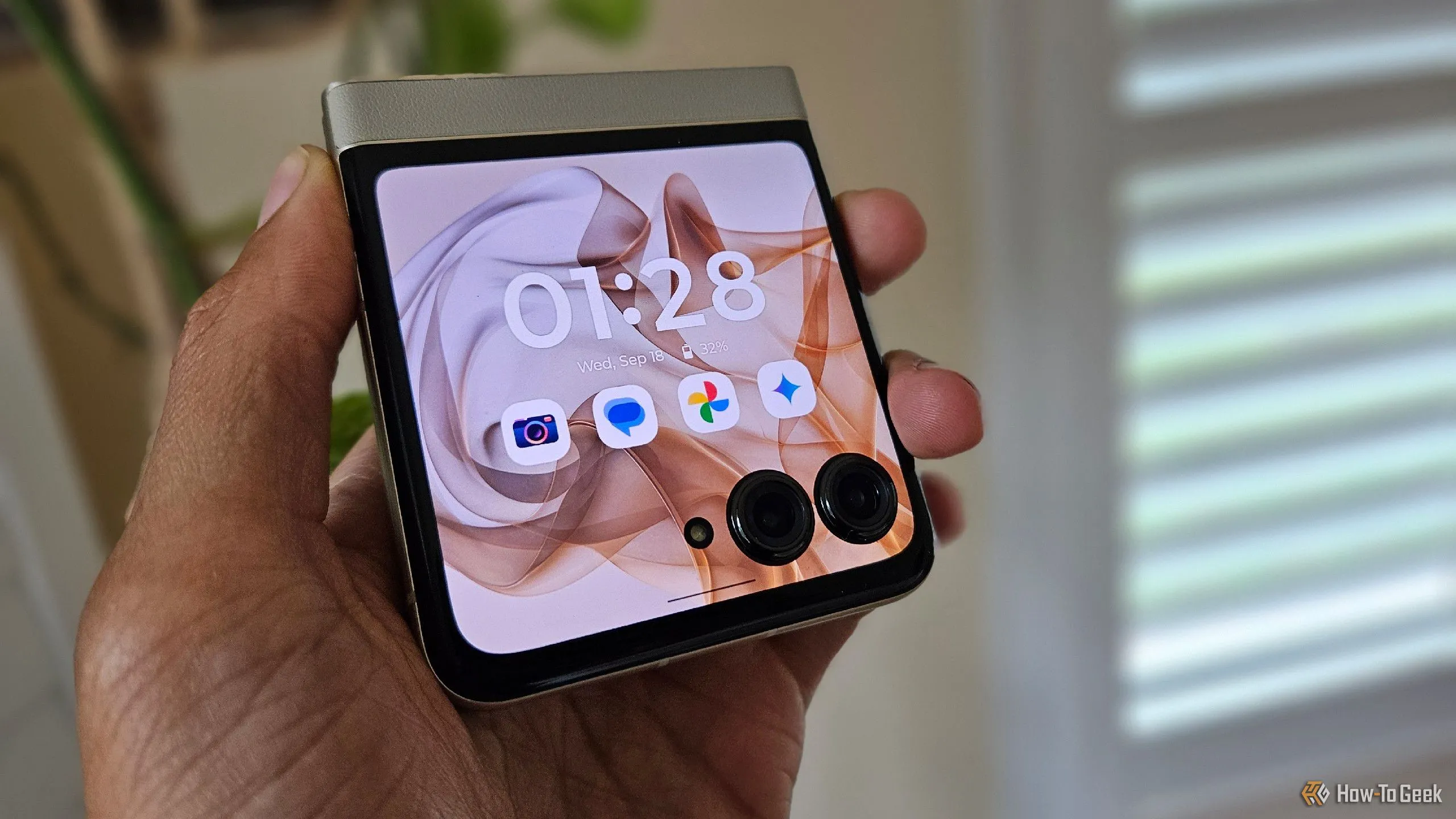 Bàn tay đang cầm chiếc điện thoại gập Moto Razr 2024 ở trạng thái đóng, thể hiện sự nhỏ gọn.