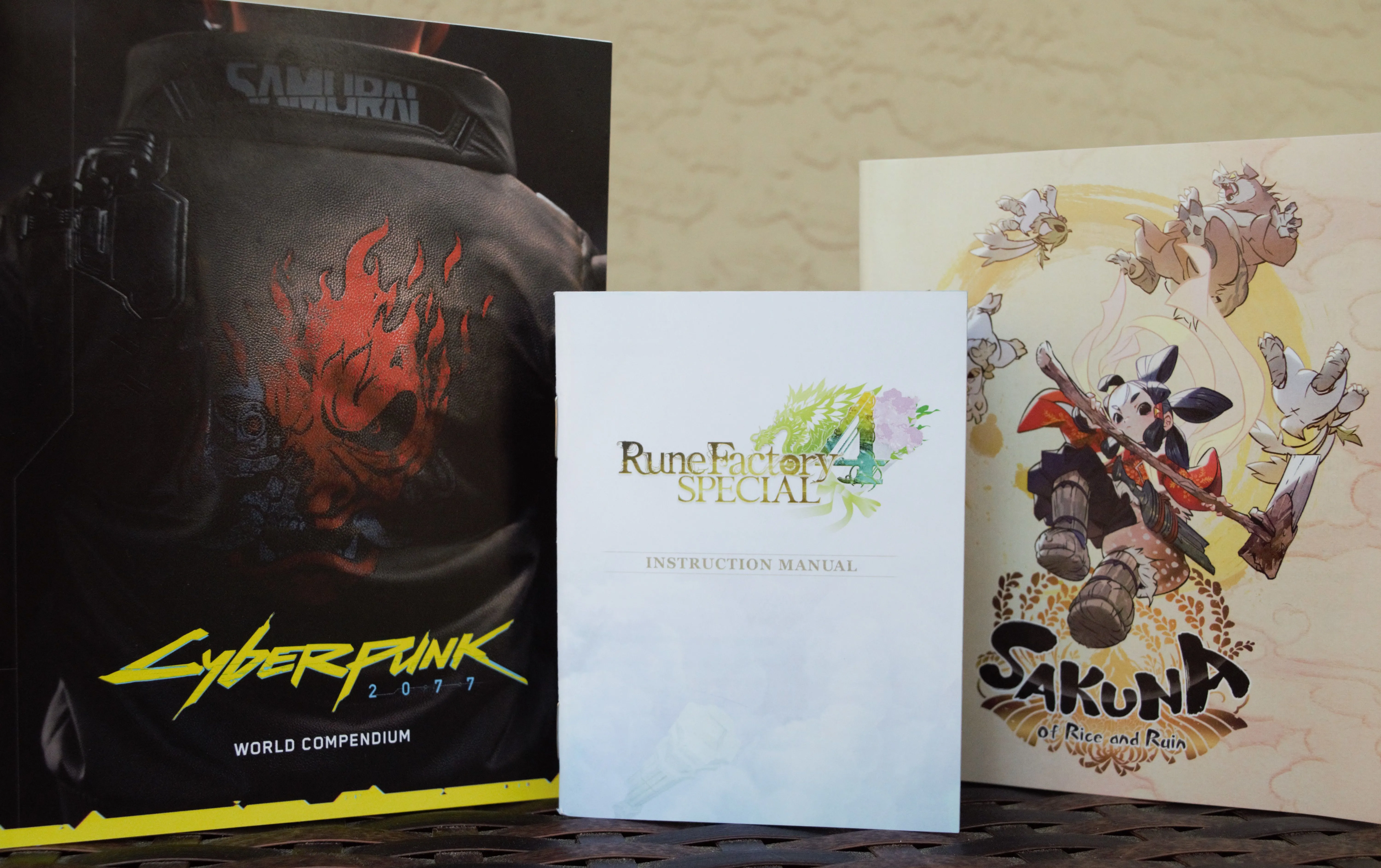 Bộ sưu tập sách hướng dẫn hoặc tài liệu đi kèm các game hiện đại như Cyberpunk 2077, Rune Factory 4 Special và Sakuna: Of Rice and Ruin.