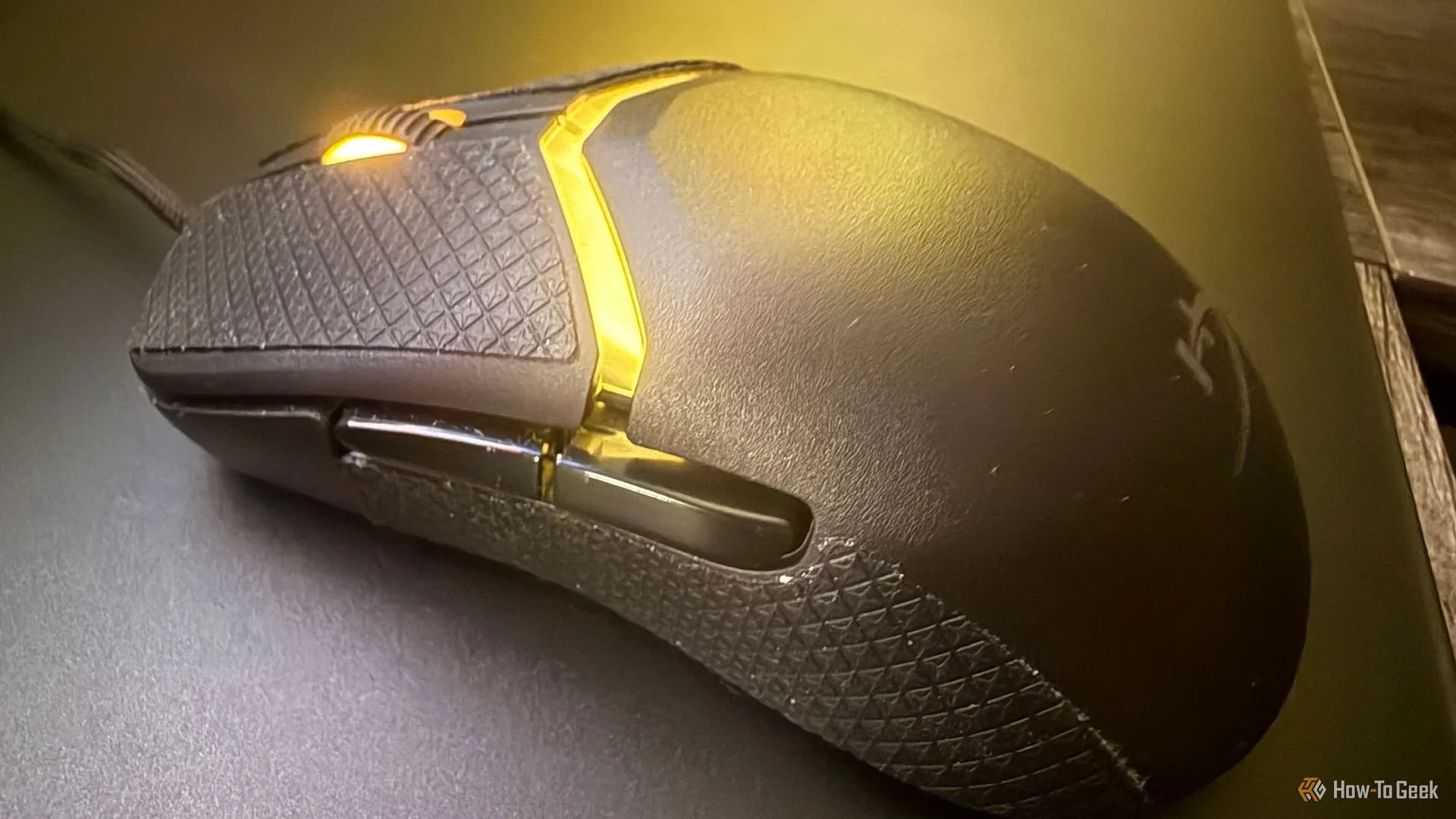 Cận cảnh nút bấm, dải chống trượt và con lăn nhỏ của chuột HyperX Pulsefire Saga, minh họa các chi tiết vật lý