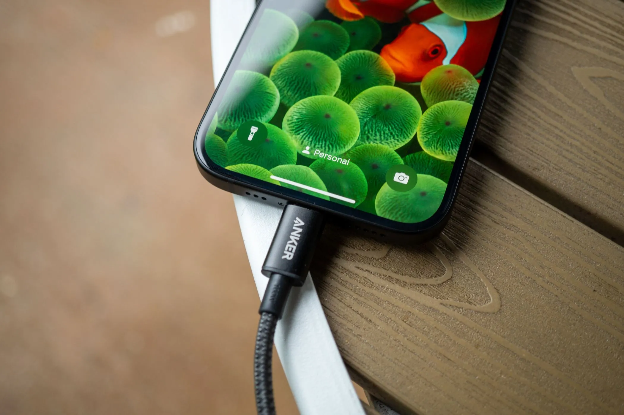 Cáp USB Type-C đang cắm vào cổng sạc của điện thoại Apple iPhone 15 để sạc nhanh.