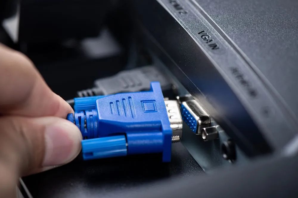 Cổng kết nối VGA màu xanh dương và cáp tín hiệu, minh họa một trong các loại cổng kết nối màn hình thông dụng nhưng đã cũ.