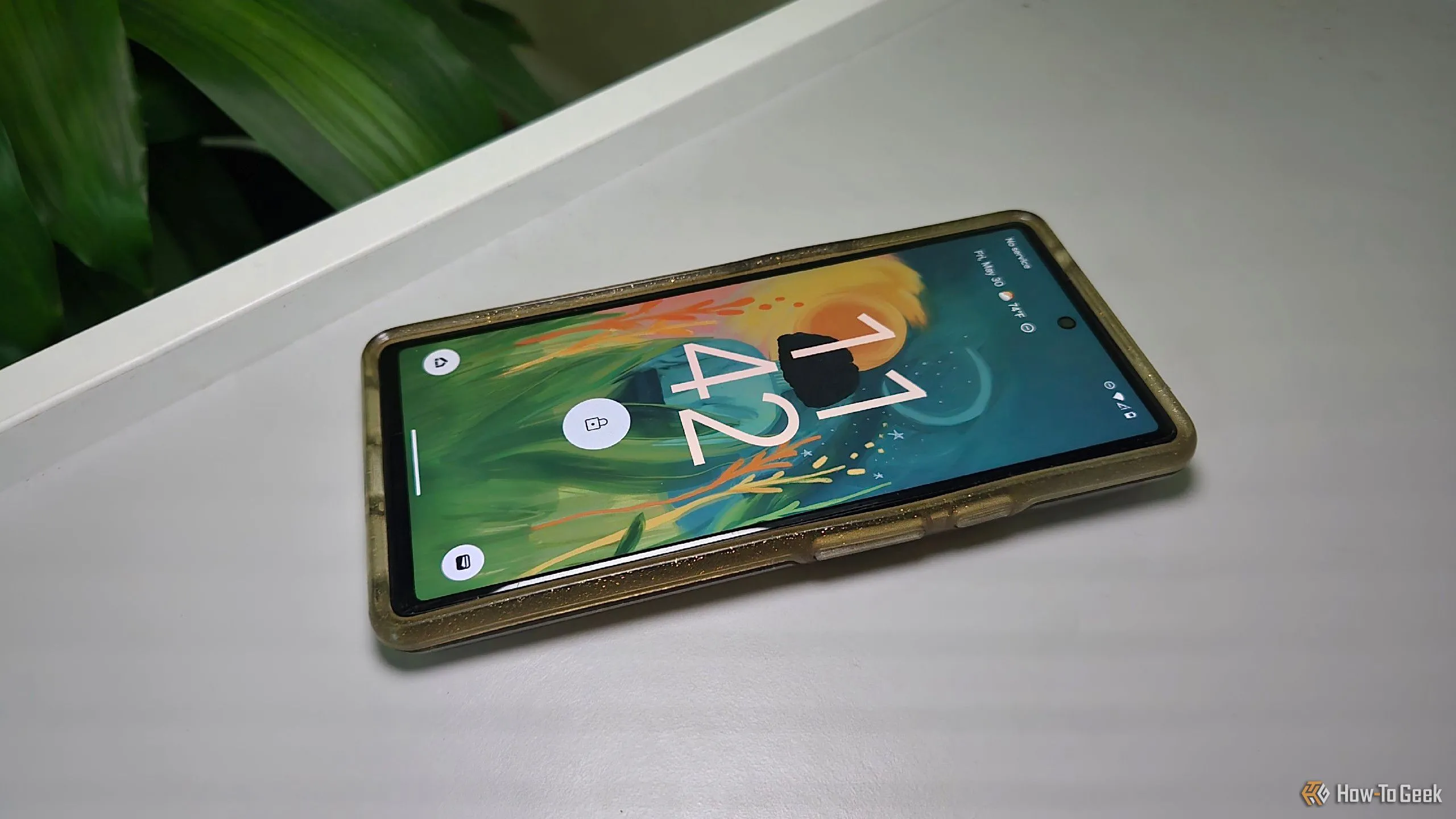 Điện thoại Google Pixel 6 màu xanh mint trong ốp lưng, đặt trên bàn làm việc, cho thấy sự cồng kềnh và che khuất thiết kế gốc.
