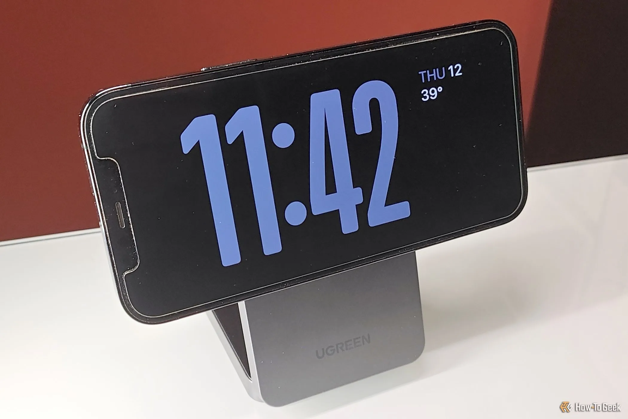 Điện thoại iPhone hiển thị chế độ StandBy trên giá đỡ sạc không dây MagFlow Qi2