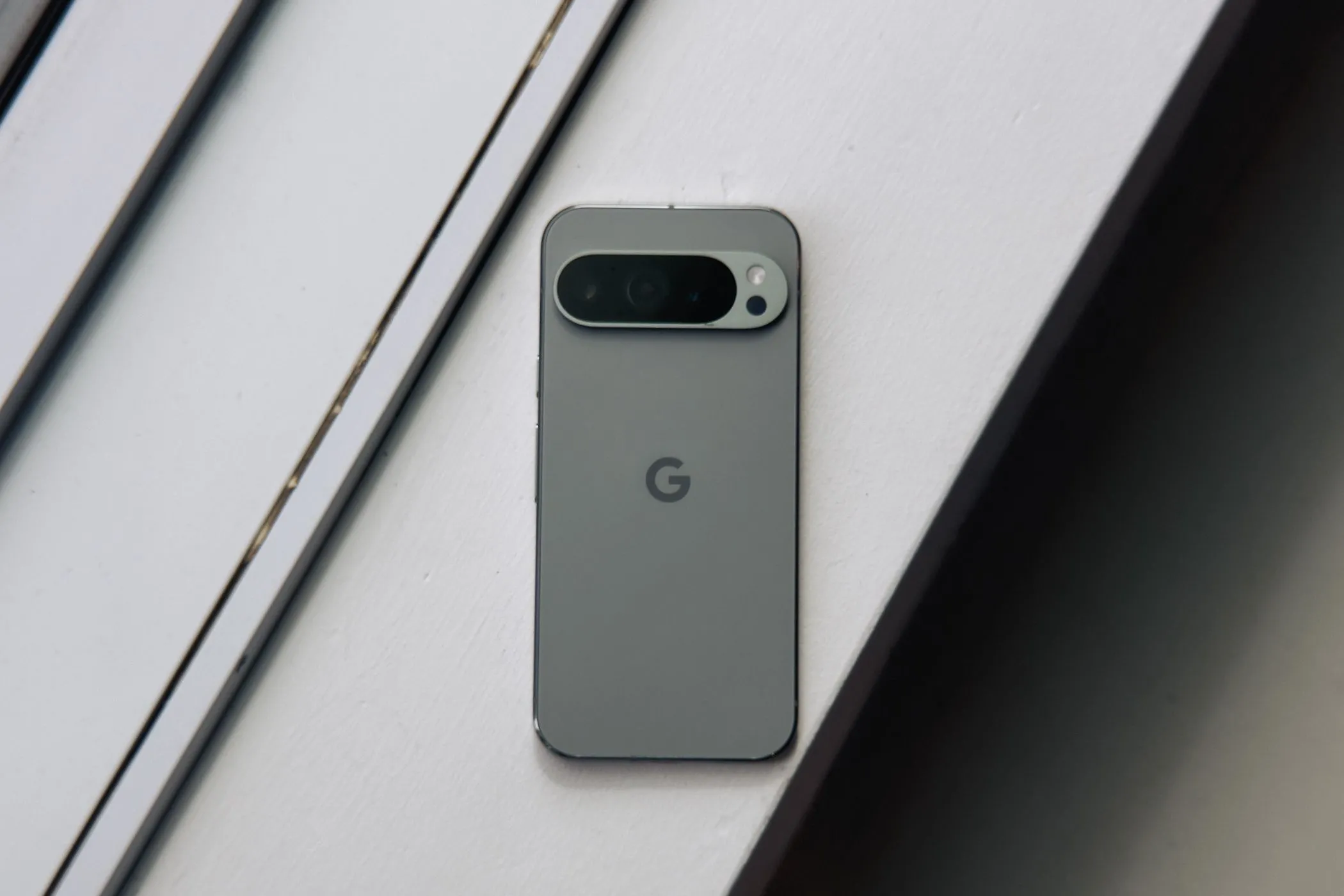 Điện thoại Pixel 9 Pro XL màu xanh lá cây đặt trên nền trắng, nổi bật thiết kế thanh lịch.