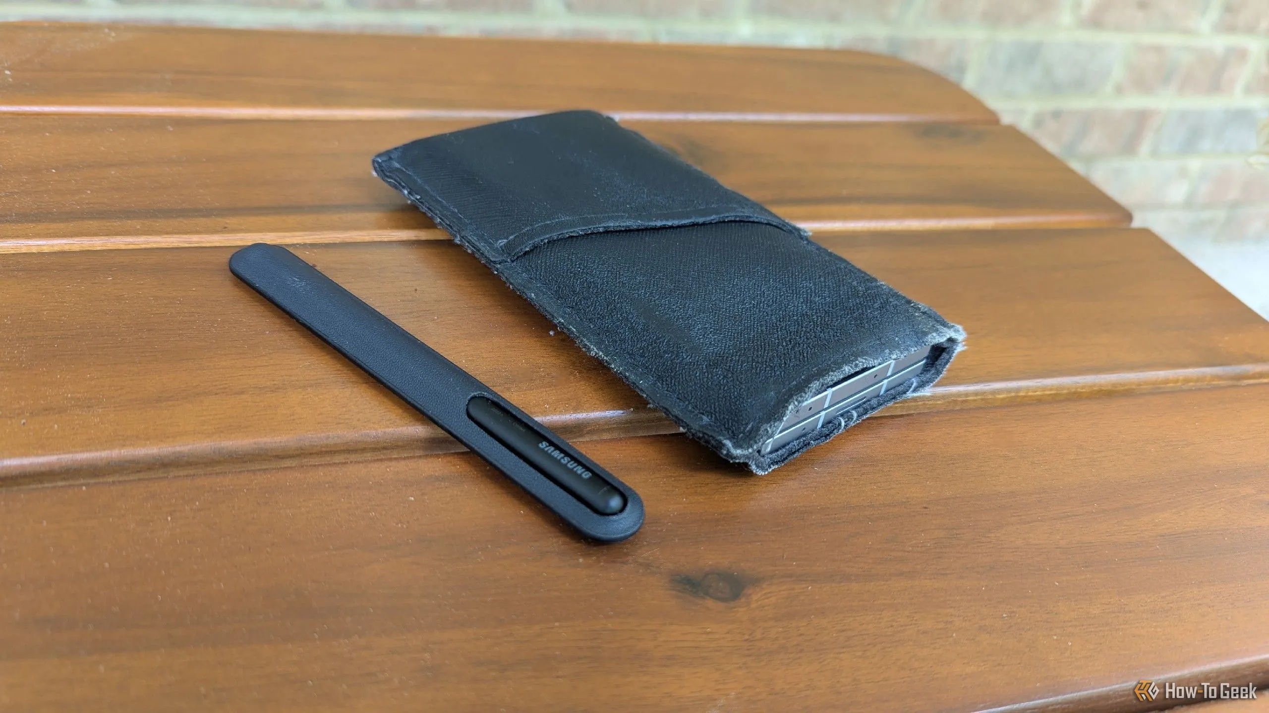 Điện thoại Samsung Galaxy Z Fold 6 cùng bút S Pen được đặt gọn gàng trong một bao da mềm, thể hiện giải pháp bảo vệ tối ưu mà vẫn giữ được vẻ đẹp nguyên bản của thiết bị.