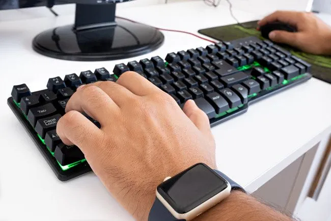 Game thủ máy tính đang sử dụng bàn phím WASD và chuột gaming để chơi game.