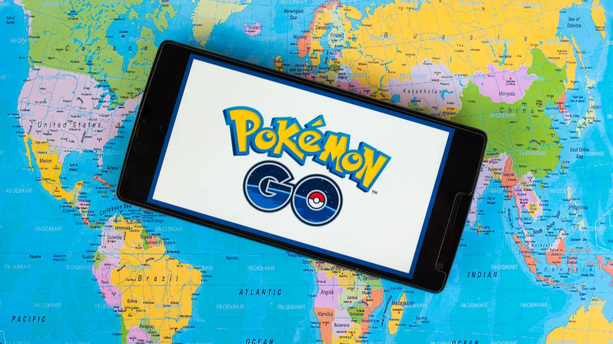Giao diện trò chơi Pokémon GO hiển thị bản đồ thế giới thực với các PokéStop và Gym, minh họa việc game yêu cầu người chơi di chuyển bên ngoài.