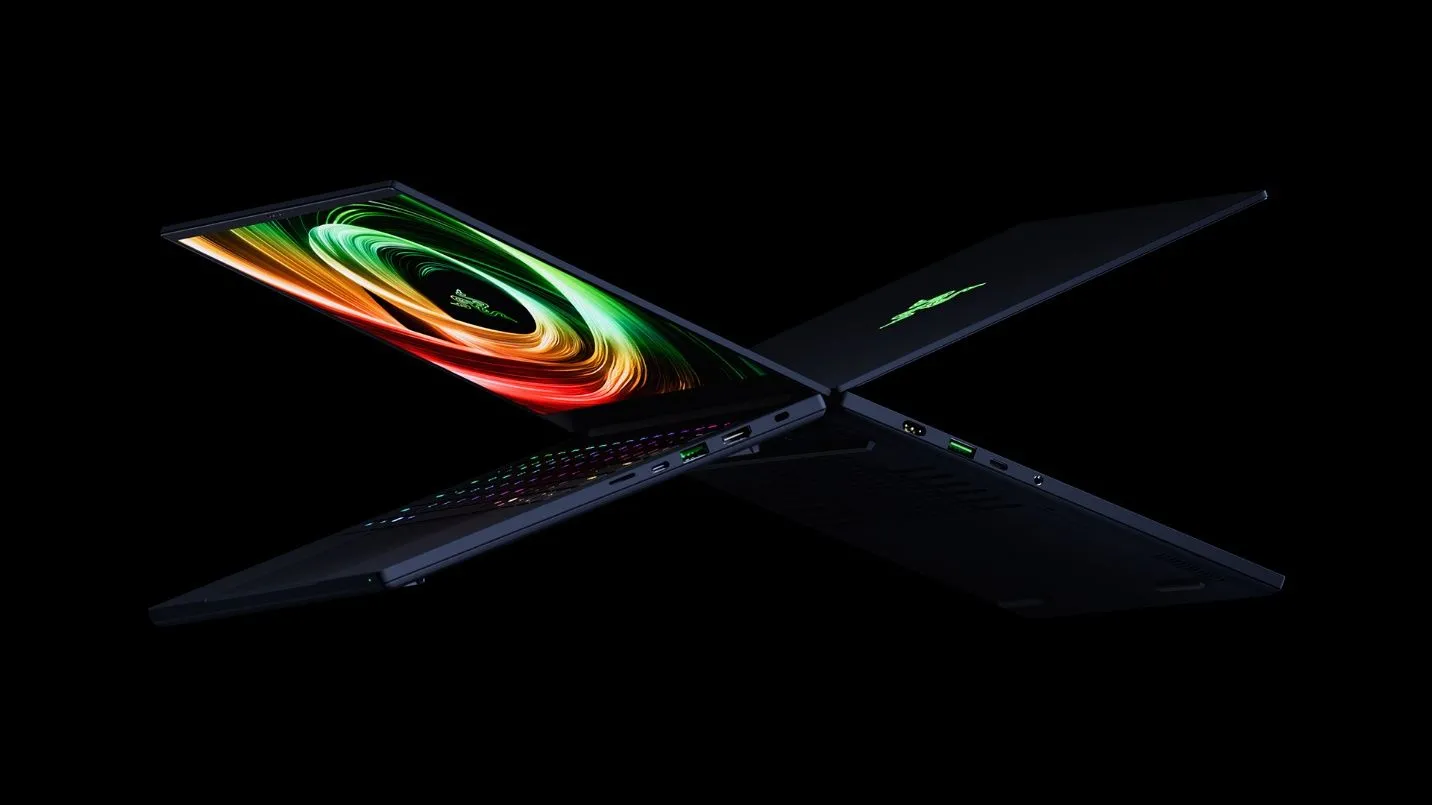 Hai laptop Razer Blade 14 đặt lưng đối lưng, hiển thị thiết kế mỏng nhẹ và màn hình OLED sắc nét, làm nổi bật các cổng kết nối.
