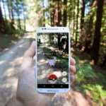 Hình ảnh người chơi tương tác với Pokémon trong game Pokémon GO trên điện thoại, minh họa khả năng thực tế tăng cường (AR) trên di động.