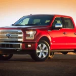 Hình ảnh xe bán tải Ford F-150 đời 2015 màu đỏ đỗ trên nền sỏi, minh họa mẫu xe bị điều tra lỗi hộp số.