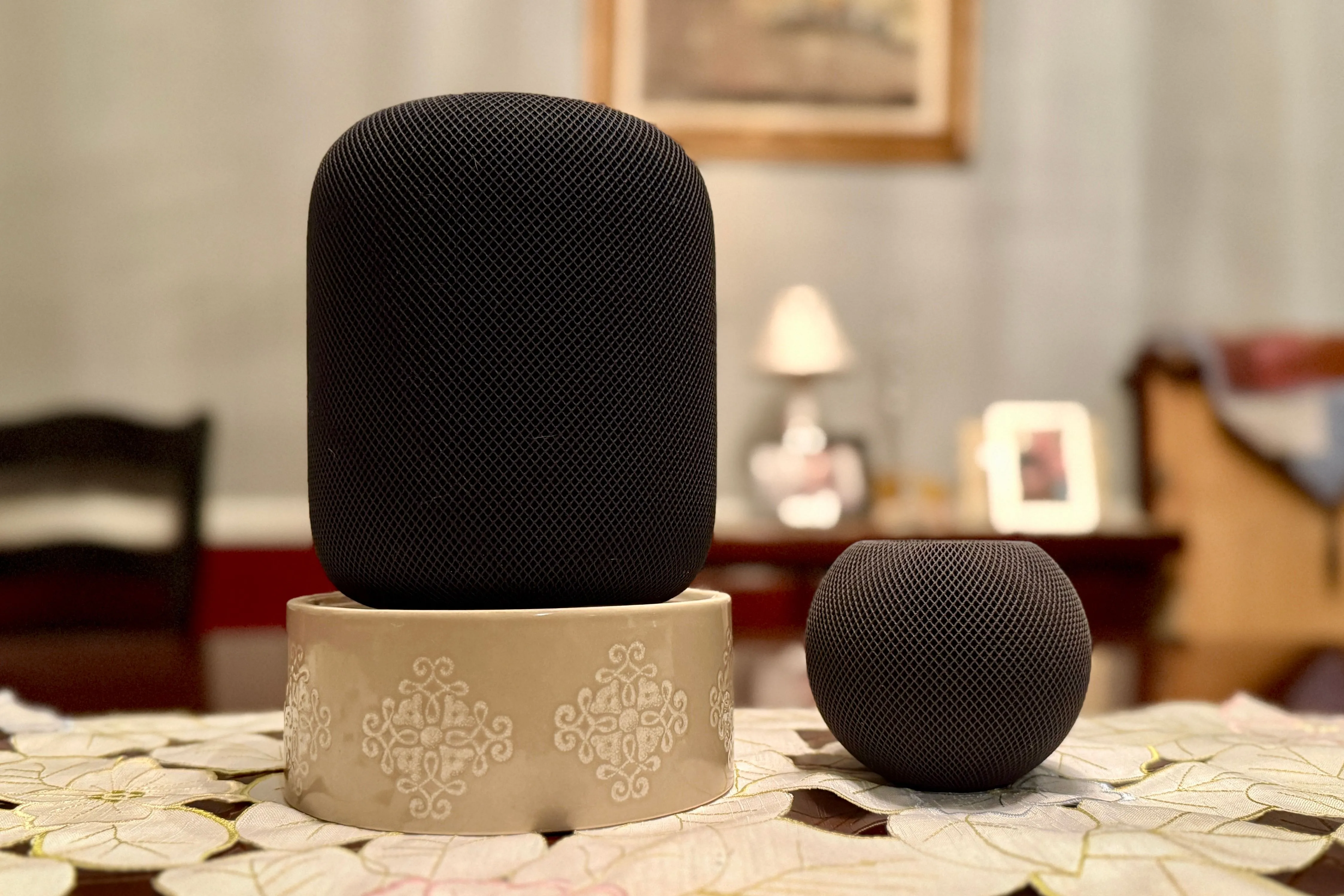 HomePod màu đen đứng cao hơn HomePod mini, thể hiện rõ sự khác biệt về kích thước.