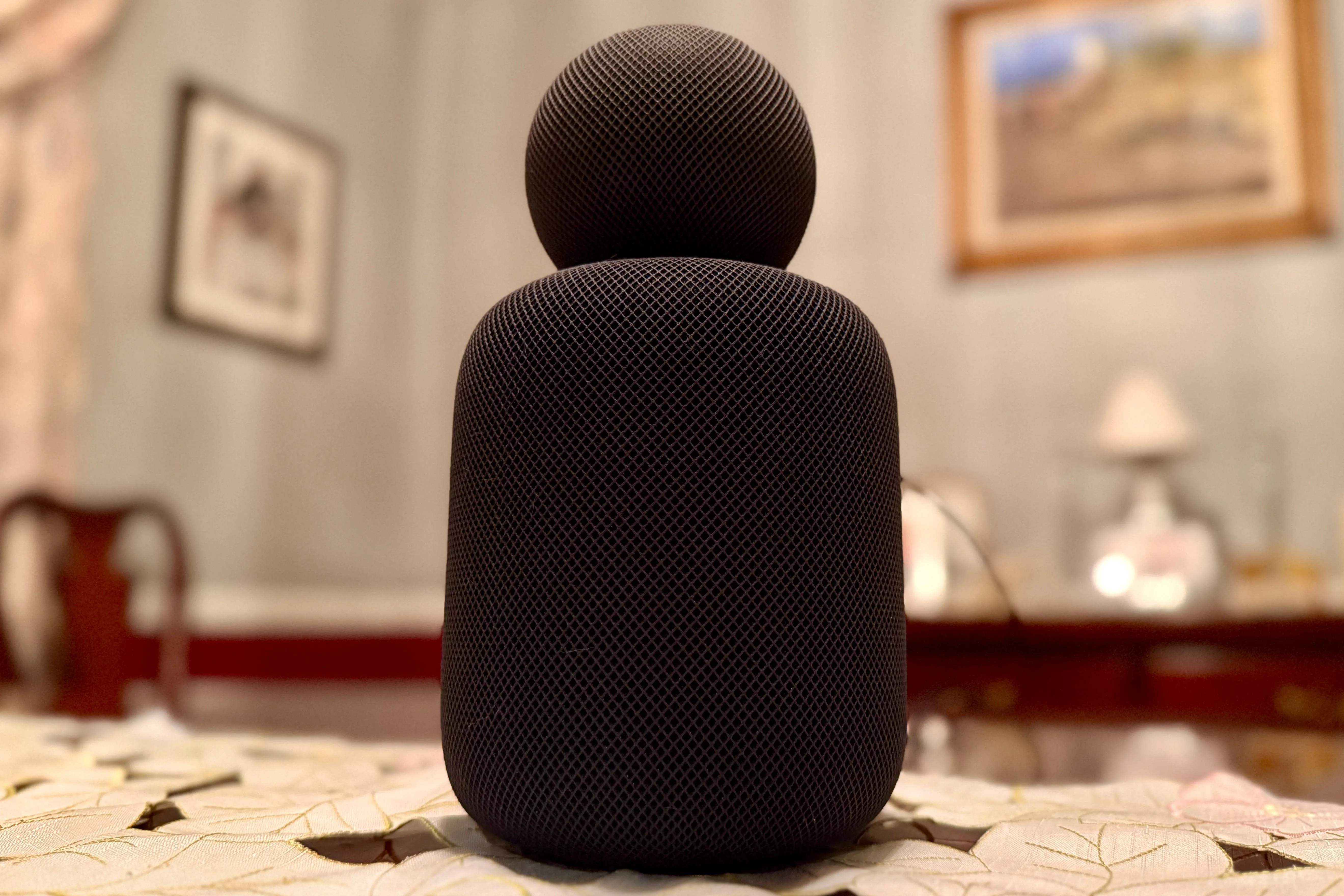 HomePod mini màu đen đứng trên HomePod màu đen kích thước đầy đủ.