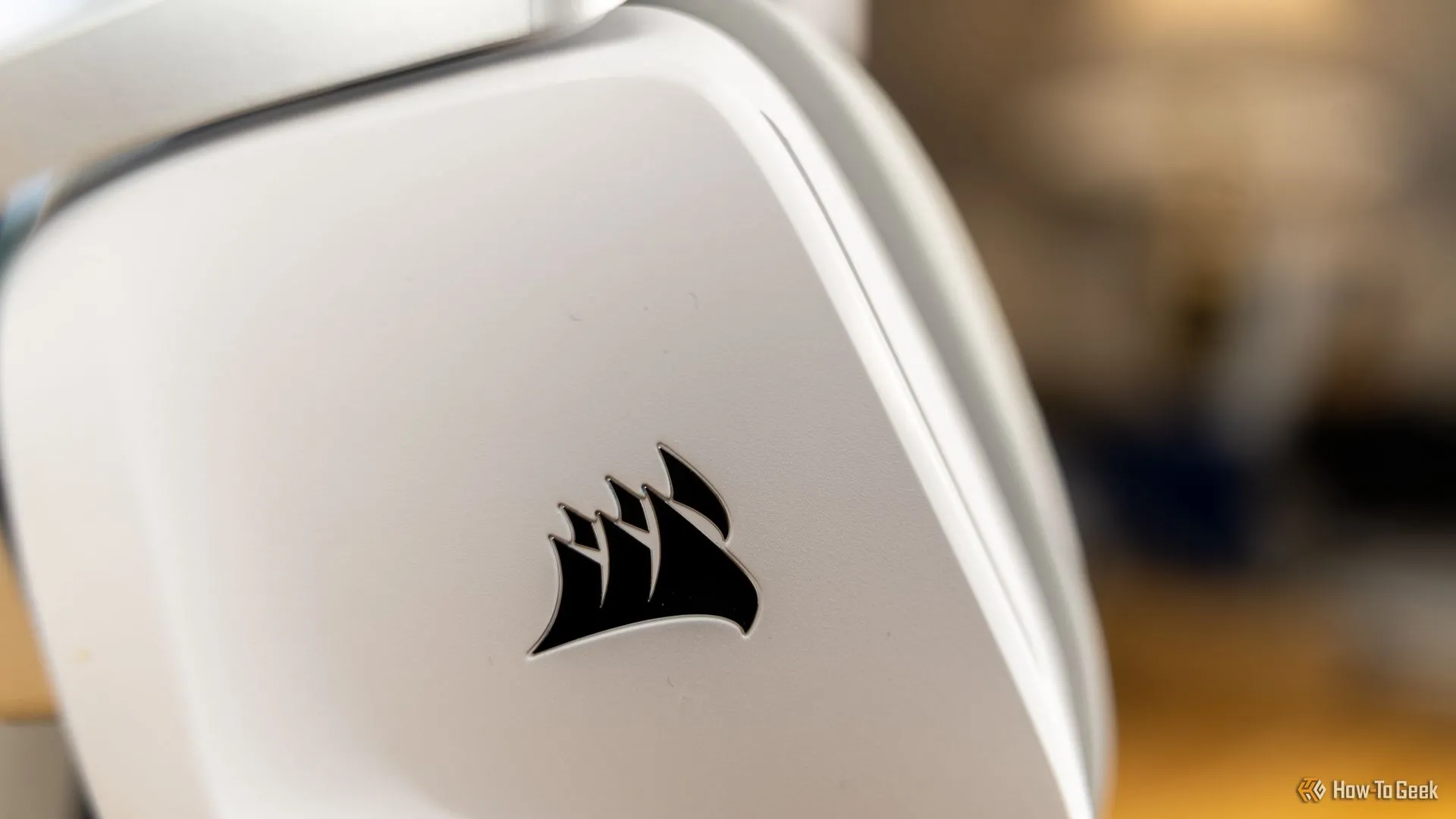 Logo CORSAIR tinh tế trên thân tai nghe gaming Corsair Void Wireless V2 màu trắng, nhấn mạnh thương hiệu.