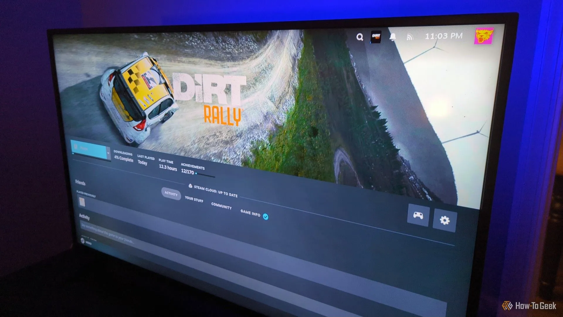 Màn hình TV hiển thị giao diện Steam đang cài đặt trò chơi Dirt Rally.