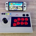 Máy chơi game cầm tay Nintendo Switch OLED kết nối với 8BitDo Arcade Stick đang hiển thị game Street Fighter 2