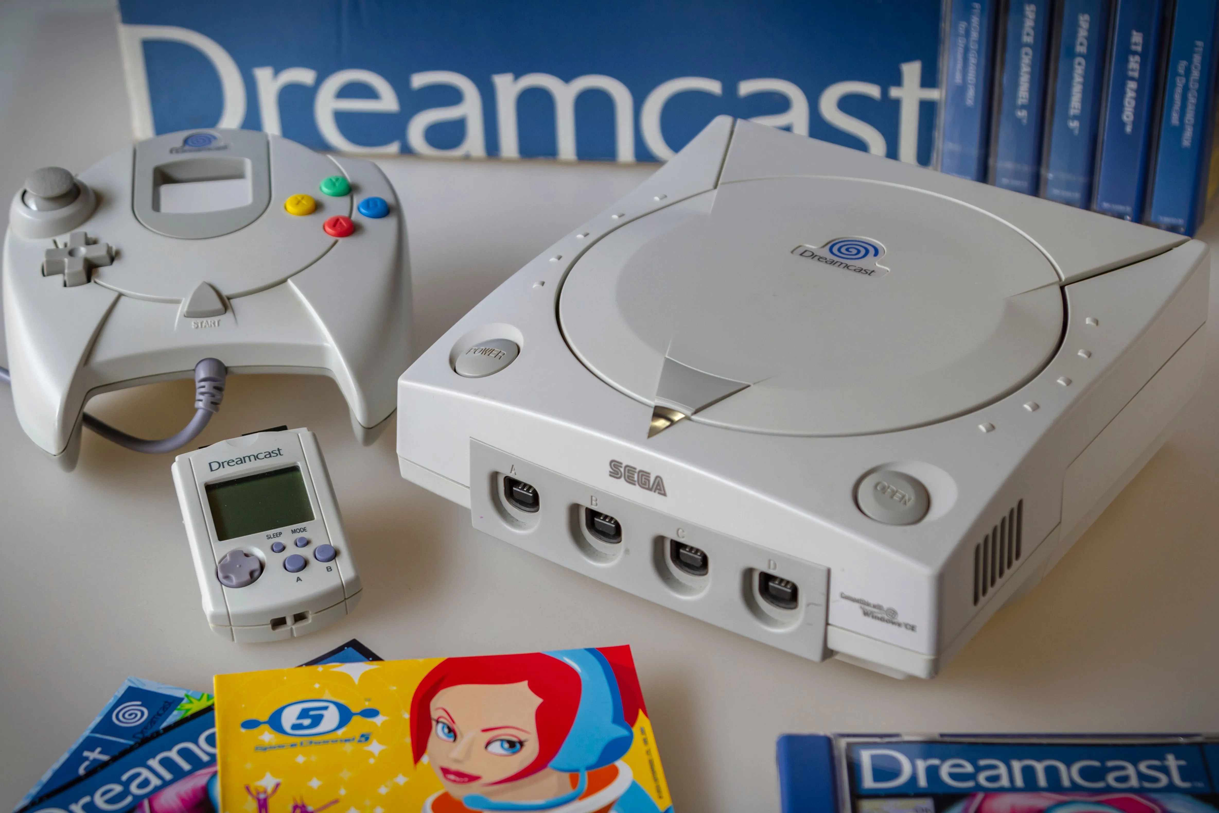 Máy chơi game Sega Dreamcast cùng tay cầm và thẻ nhớ VMU, biểu tượng của một console thất bại nhưng dẫn đến thành công về phần mềm của Sega.
