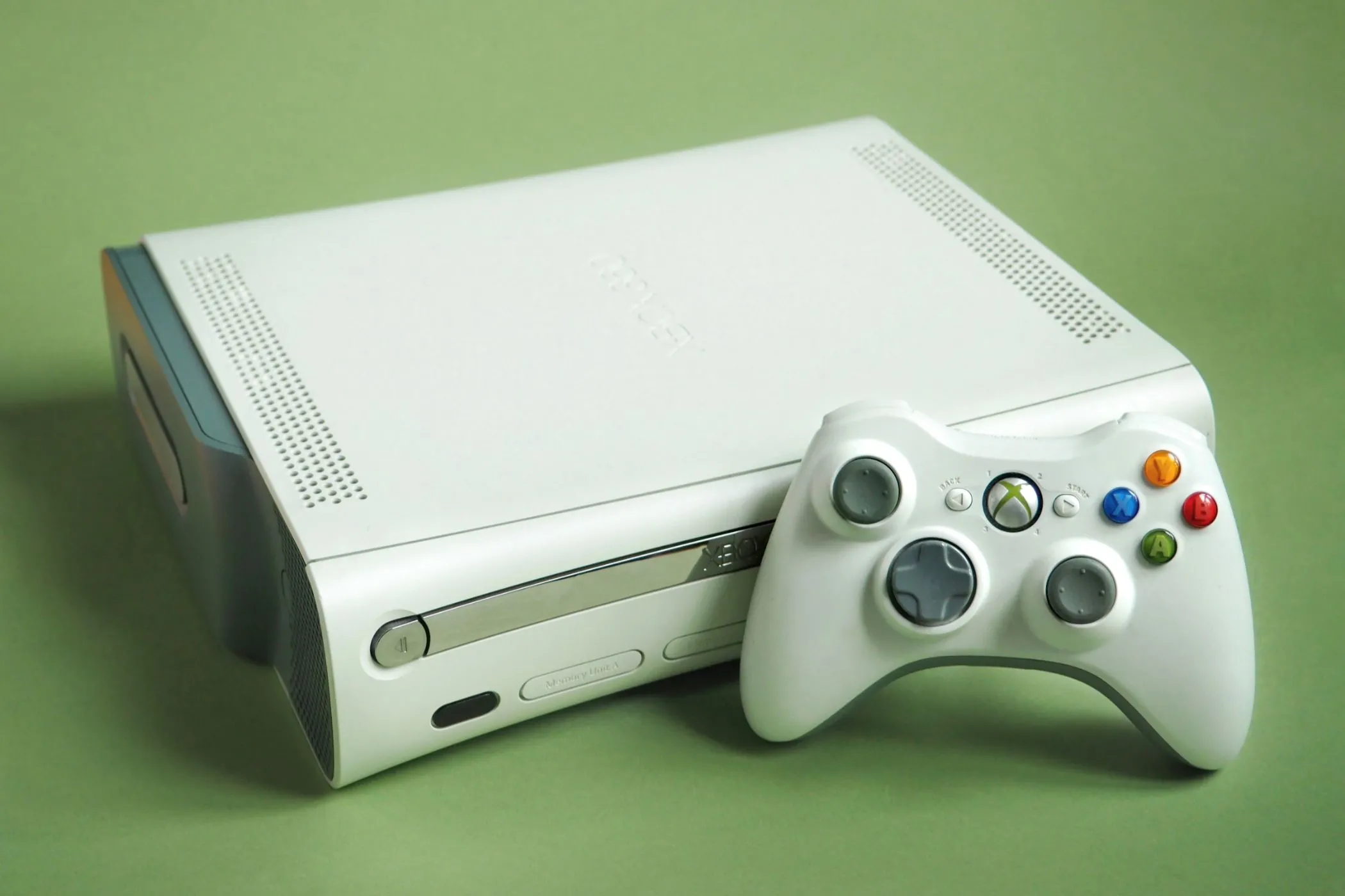 Máy chơi game Xbox 360 màu trắng cùng tay cầm điều khiển, biểu tượng cho kỷ nguyên thành tích game hiện đại.