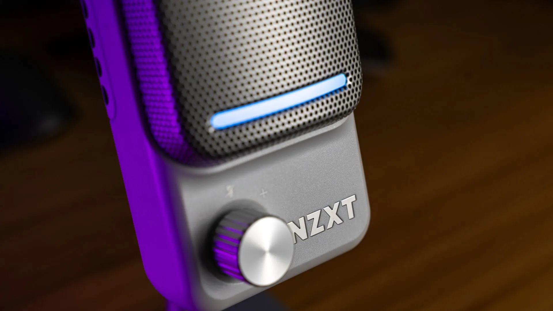 Microphone NZXT Capsule Elite nhìn từ bên cạnh, hiển thị núm điều chỉnh gain, thanh đèn và logo.