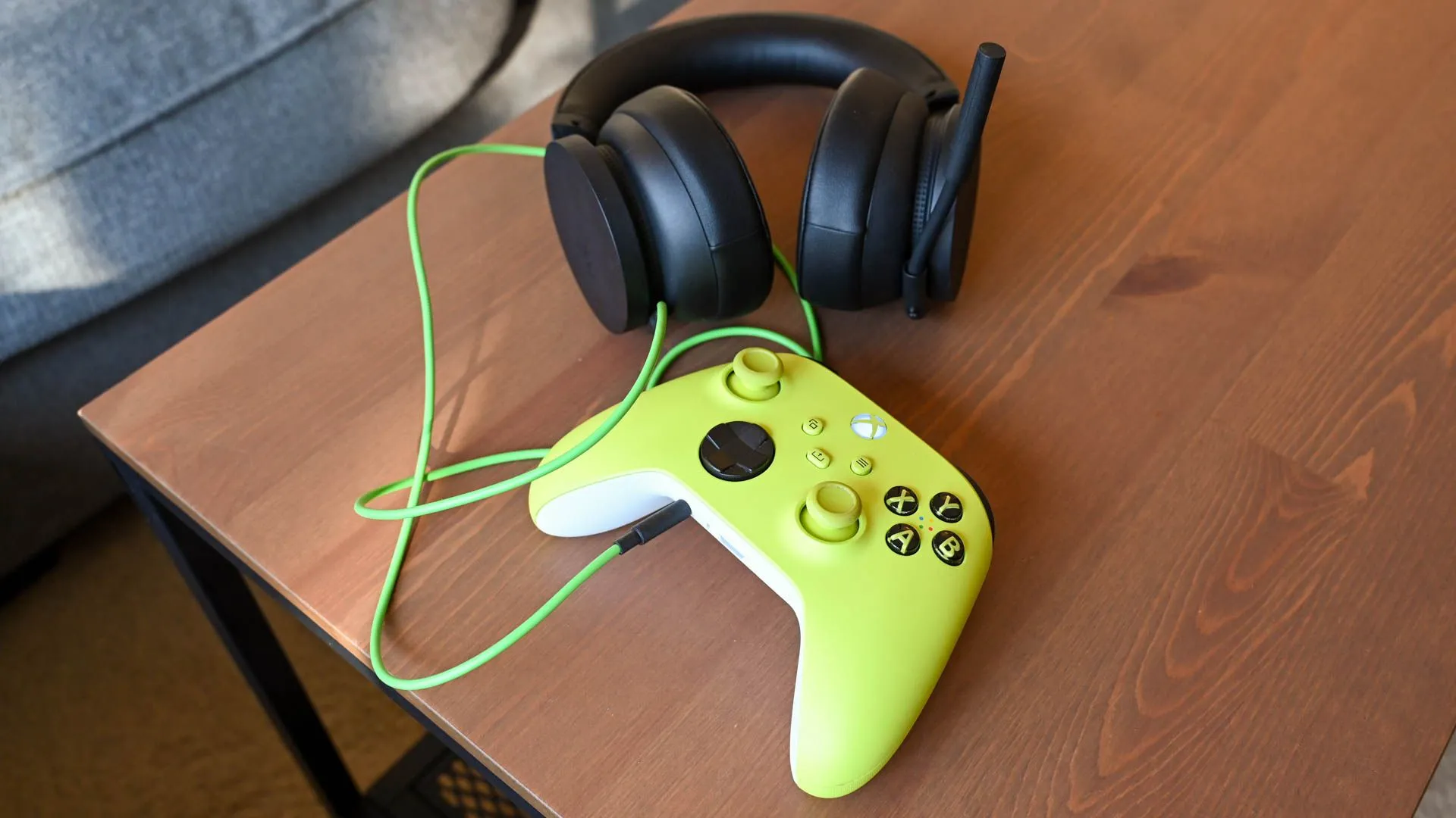 Một chiếc tai nghe gaming và tay cầm Xbox Series X được đặt trên bàn, thể hiện sự kết hợp cho trải nghiệm chơi game online