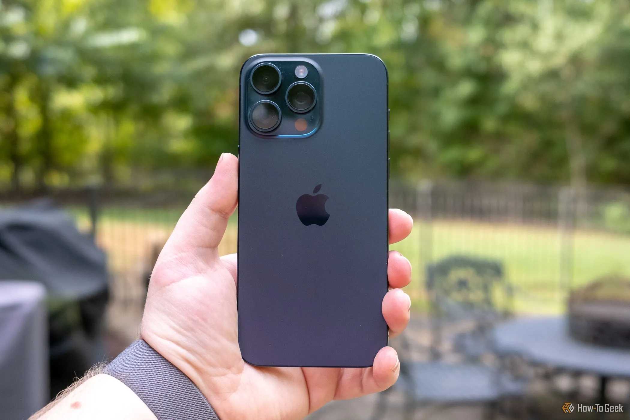 Một người dùng đang cầm iPhone 15 Pro Max, thiết bị nổi bật với khả năng nhiếp ảnh di động hàng đầu.