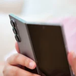Người dùng cầm điện thoại Samsung Galaxy Z Fold 6 đang mở nhẹ, nhìn vào cụm camera sau, minh họa sự trưởng thành của thiết bị gập