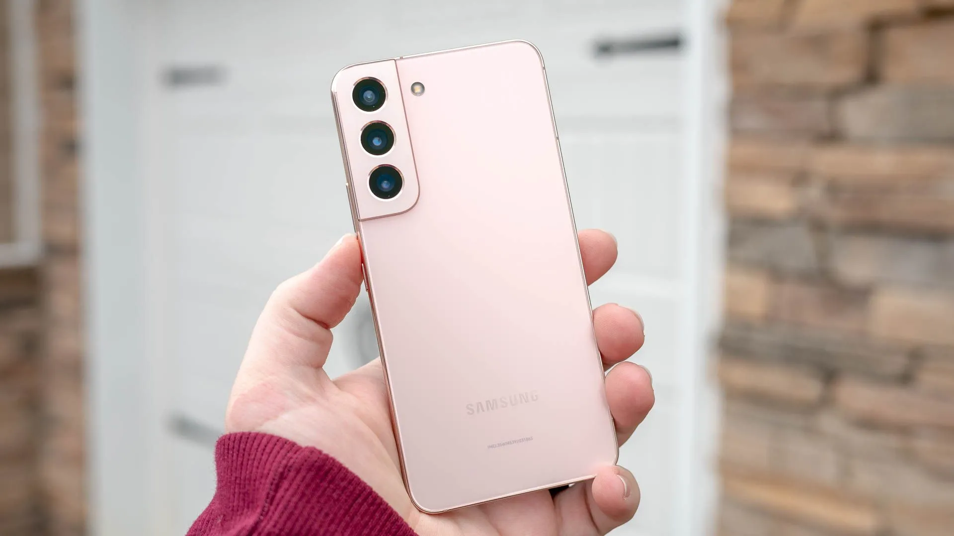Người dùng đang cầm chiếc điện thoại Galaxy S22, thể hiện việc lựa chọn smartphone dựa trên các yếu tố khác nhau.