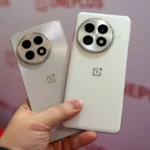 Người dùng đang cầm hai mẫu điện thoại OnePlus 13 và OnePlus 13R màu trắng, minh họa cho bản cập nhật Android 16.
