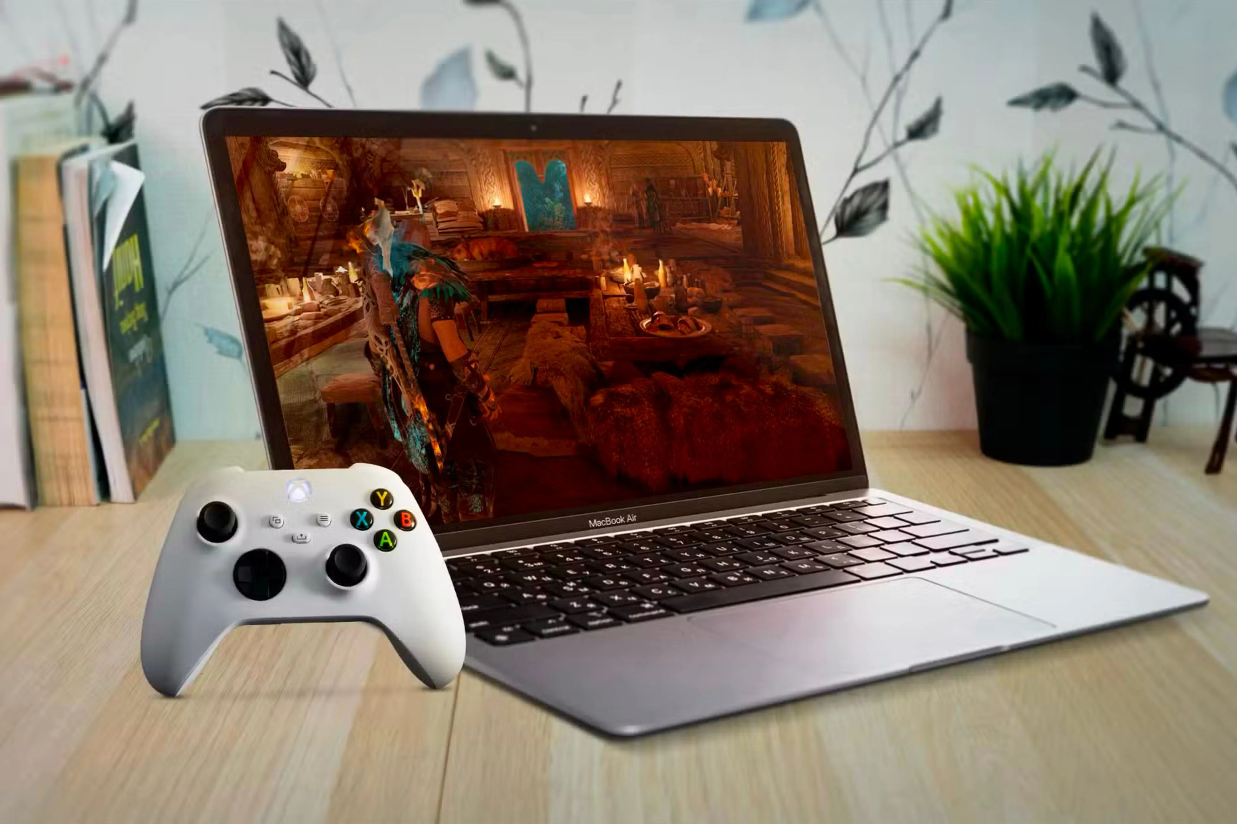 Người dùng đang chơi game trên MacBook Air với tay cầm Xbox, minh họa khả năng giải trí của Mac bên cạnh công việc.