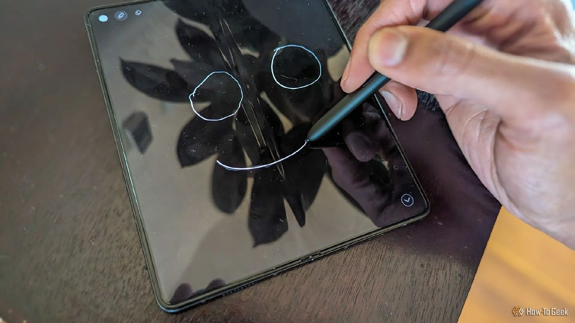 Người dùng đang vẽ hoặc ghi chú bằng bút S Pen trên màn hình Samsung Galaxy Z Fold 5 mở ra.