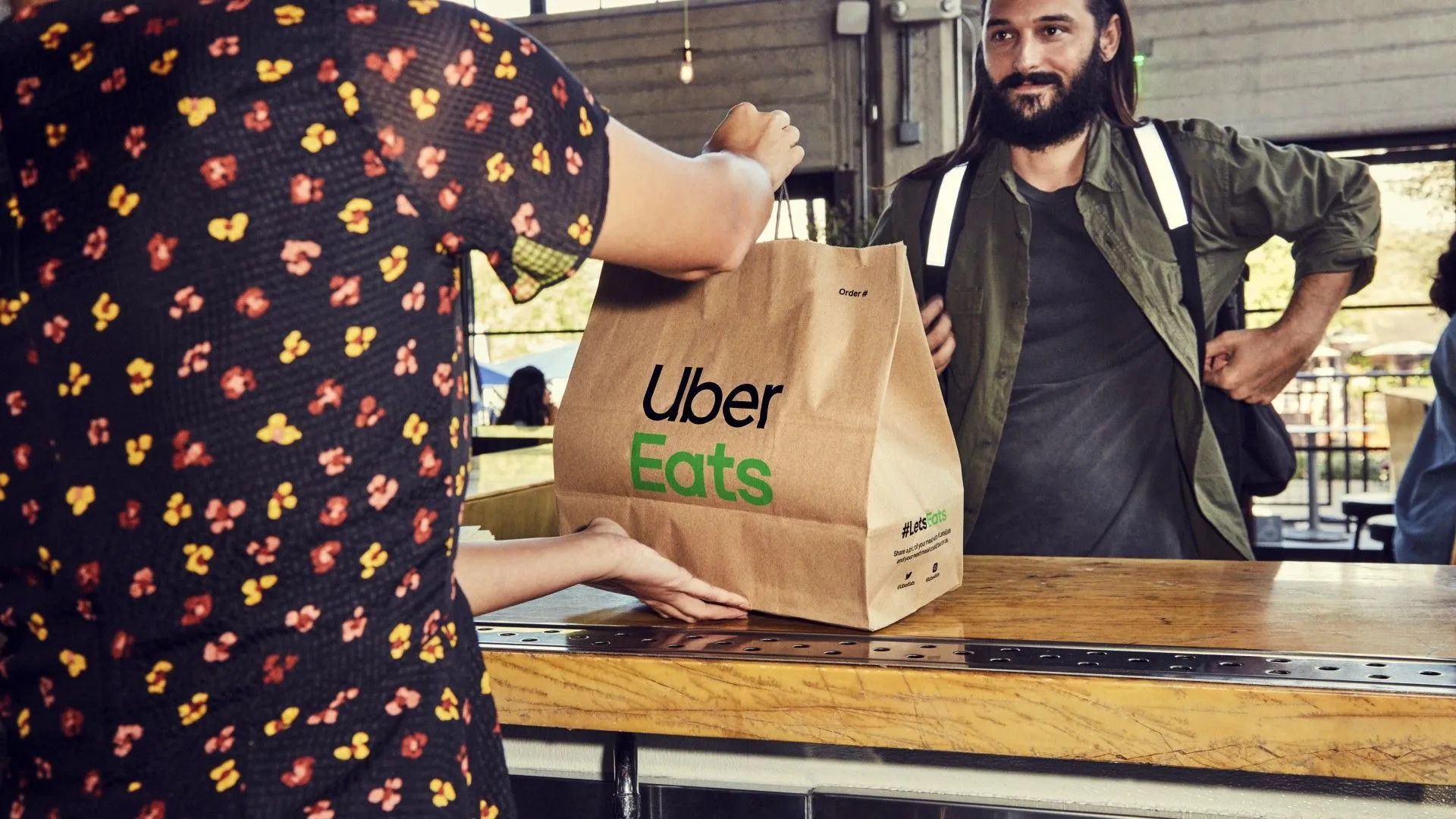Người giao hàng Uber Eats nhận túi đồ ăn từ nhà hàng.