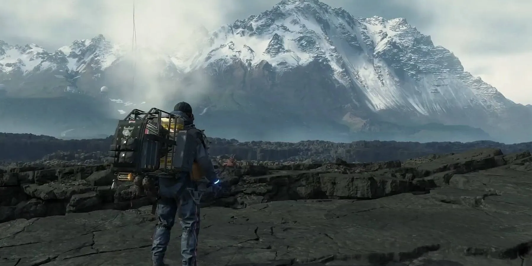 Sam Porter Bridges di chuyển qua địa hình hiểm trở trong Death Stranding, một game mô phỏng vận chuyển trong thế giới hậu tận thế.