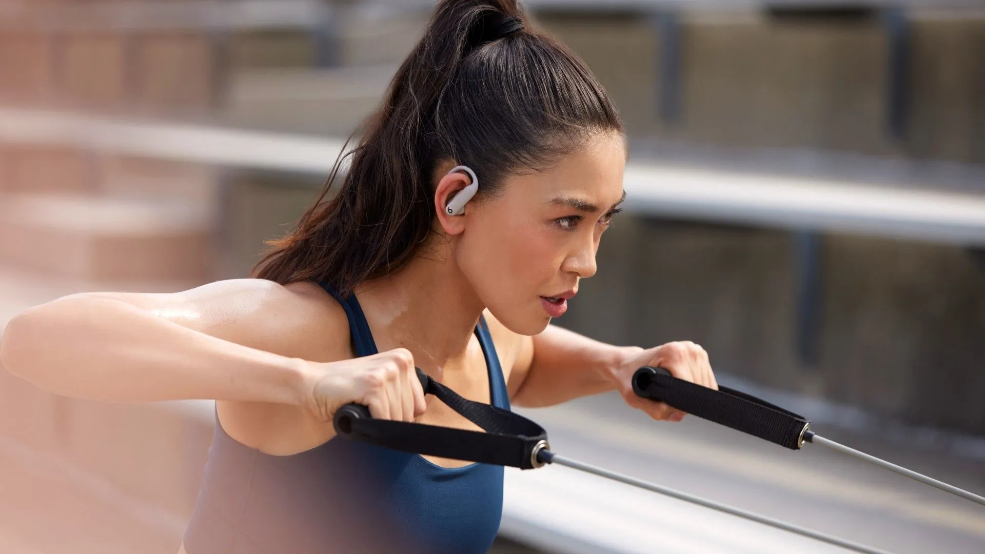 Tai nghe Powerbeats Pro 2 trên tai một phụ nữ đang tập thể dục