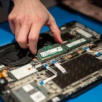 Thao tác nâng cấp RAM trên laptop Lenovo, minh họa linh kiện bên trong máy tính cũ, giúp cải thiện hiệu suất.