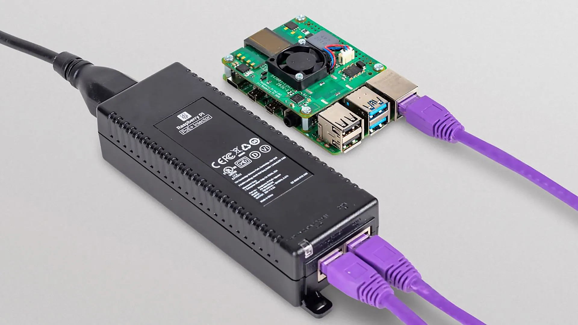 Thiết bị Raspberry Pi PoE+ Injector màu đen với các cổng Ethernet, minh họa giải pháp cấp nguồn qua mạng cho các thiết bị IoT và máy tính nhúng